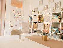 Innenraum mit Regalen voller Spiele, Kinderzeichnungen an der Tür und gemütlicher Einrichtung