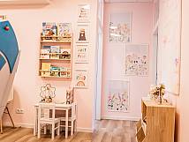 Heller Raum mit Kindermöbeln, Büchern und Wandbildern in freundlicher Farbgestaltung