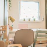 Innenraum mit kindgerechter Einrichtung, Fensterdeko und organisiertem Schreibtisch