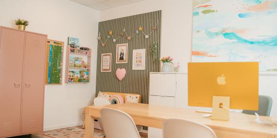 Innenraum mit Tisch, Stühlen, Kinderecke, farbigen Möbeln und kreativer Wandgestaltung